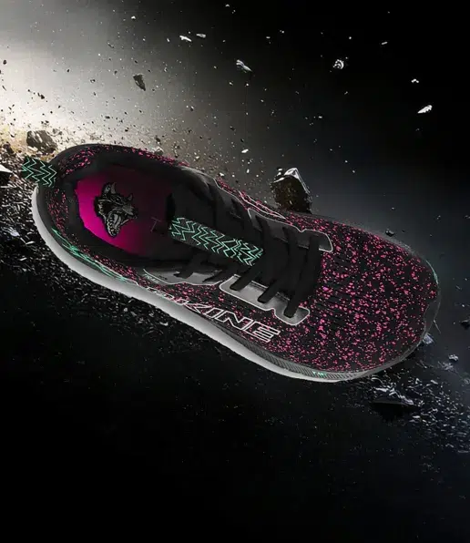 A black SBR Collective trainer with pink speckles, a teal zigzag design on the tongue, and a white sole is displayed on a dark, cosmic-like background with small floating debris.